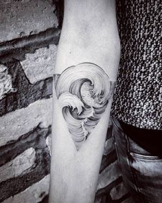 a black and white photo of a man's arm with a wave tattoo on it