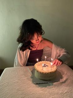 a woman blowing out candles on a cake