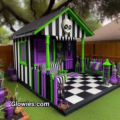 a small purple and green house with black and white checkered flooring in the yard