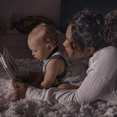 a woman and her baby reading a book together