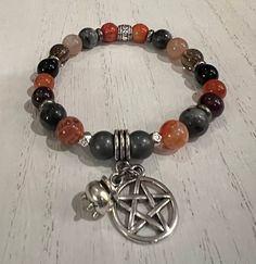 "Happy Halloween and a Blessed Samhain! This beautiful stretch bracelet features a selection of semi precious to aid in communication with the ancestors, increasing intuition, connecting to past, present and future, balance, protection and delving into deep wisdom. Each bracelet will be one of a kind and made to order. A pentacle and tiny cauldron charm set off the bracelet with your choice of antique silver or antique bronze elements. Please know that each bracelet I make is truly one-of-a-kind Spiritual Silver Stretch Bracelet With Gemstone, Spiritual Gemstone Beads Stretch Bracelet For Meditation, Spiritual Gemstone Beads Bracelet For Meditation, Silver Spiritual Healing Stretch Bracelet, Adjustable Spiritual Bracelet For Healing, Adjustable Spiritual Stretch Bracelet For Healing, Multicolor Spiritual Stretch Bracelet, Spiritual Stretch Bracelet With Gemstone Beads For Healing, Spiritual Beaded Bracelets With Natural Stones