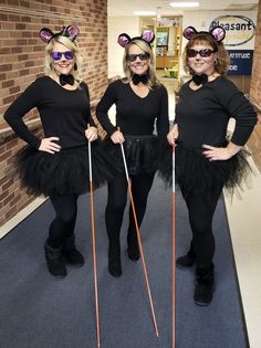 three women dressed up in costumes and holding ski poles