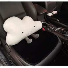 a stuffed animal sitting in the middle of a car seat with its head resting on it's pillow