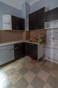 an empty kitchen is shown in the middle of being painted brown and white with black cabinets