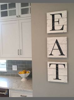 three wooden signs mounted on the wall above a kitchen counter top with lemons in a bowl