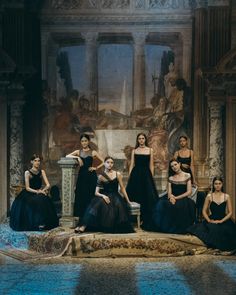 a group of women in black dresses posing for a photo