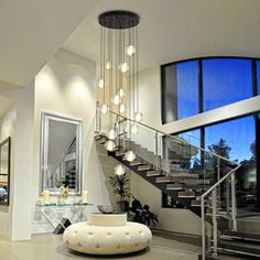 a large living room with stairs and chandelier