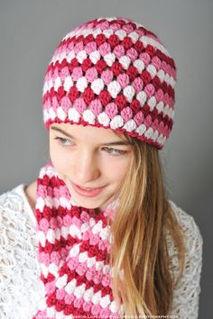 a woman wearing a pink and white crocheted hat