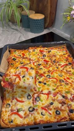 a square pizza sitting on top of a pan covered in cheese and veggies