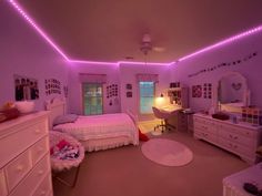 a bedroom with pink lights and white furniture in it's center area is lit up by purple leds