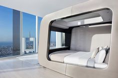 a bedroom with a bed in the middle of it and a view of the city