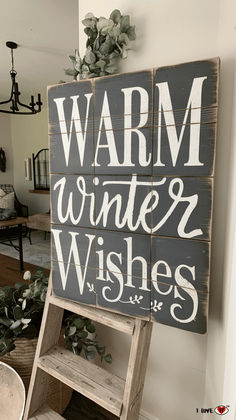 a wooden sign that says warm winter wishes on the side of a wall in a living room