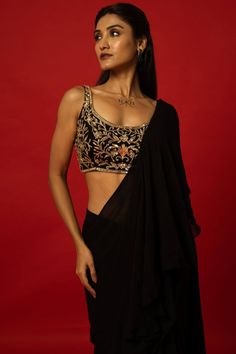 This elegant Black Ruffle Saree features a unique hand-embroidered stitched blouse for a one-of-a-kind look. The carefully crafted details add a touch of sophistication and style to any occasion. Perfect for those looking to make a statement with their traditional attire. Black Ruffle Saree, Saree Drapes, Baluchari Saree, Golden Blouse, Saree Blouse Styles, Silver Blouse, Net Blouses, Cotton Gowns, Ruffle Saree