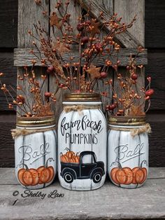 three mason jars with pumpkins painted on them