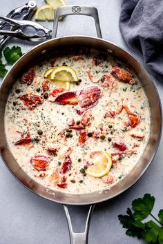 a pan filled with food and garnished with lemons