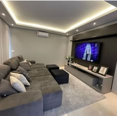 a living room filled with furniture and a flat screen tv mounted to the side of a wall