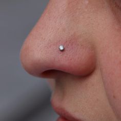 a woman's nose with a single diamond on it, and the tip of her nose is visible