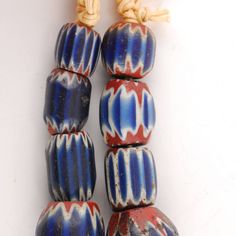 three blue and red beads are stacked on top of each other, with rope at the end