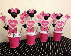 minnie mouse cupcakes are arranged in pink and black polka dot cups with name tags on them