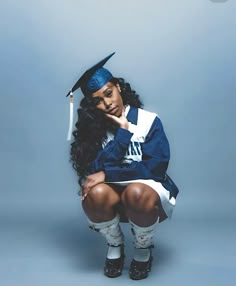 a woman in a graduation cap and gown sitting on a stool with her legs crossed