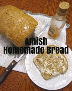 a loaf of bread sitting on top of a white plate next to a knife and bottle