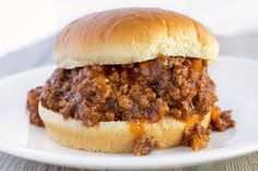 a sloppy joe sandwich sitting on top of a white plate