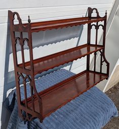 a wooden shelf sitting on top of a blue blanket next to a white wall and door