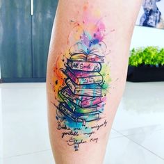 a person with a tattoo on their leg that has books stacked on top of each other