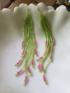 Brick stitch earrings with extra long fringe, green seed beads and pink E beads. Pink Fringe Beaded Earrings For Summer, Green Fringe Earrings For Summer, Green Tassel Jewelry For Summer, Summer Green Tassel Jewelry, Green Beaded Fringe Tassel Earrings Gift, Green Tassel Earrings With Beaded Fringe, Green Fringe Beaded Drop Earrings, Green Beaded Fringe Chandelier Earrings, Summer Green Dangle Chandelier Earrings