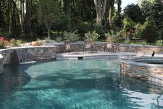 an outdoor swimming pool surrounded by stone walls