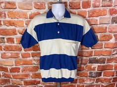 "vintage 70s/80s huk a poo polo shirt with banded waist, blue stripes, and textured white sections. Lightly used no major Flaws to note MEASURES -  19.5\" pit to pit and 26\" long TAGGED - M ~ BE SURE TO CHECK OUT MY ENTIRE SHOP ~ - This is a TRUE VINTAGE item! Vintage clothing sizing varies wildly ALWAYS use the measurements and info provided in the listing to assure proper fit! Unless the words \"deadstock\" or \"unworn\" are used please understand this is a USED item. RETURNS - My policy is N Fitted Striped Polo Shirt With Ribbed Collar, Retro Relaxed Fit Polo Collar Top, Retro Top With Relaxed Fit And Polo Collar, Retro Relaxed Fit Top With Polo Collar, Striped Relaxed Fit Collared Polo Shirt, Striped Relaxed Fit Polo Shirt, Vintage Summer Polo Collar T-shirt, Retro Polo Collar Top With Striped Detail, Retro Polo Collar Top With Stripes