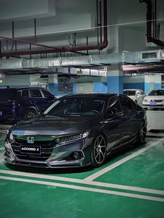 two cars parked in a parking garage next to each other on a green and white floor