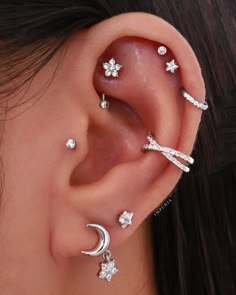 a close up of a person's ear with three piercings