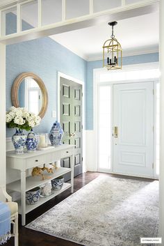 a blue and white entryway with vases on the table