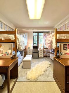 a bedroom with bunk beds and desks in it's center, surrounded by other furniture