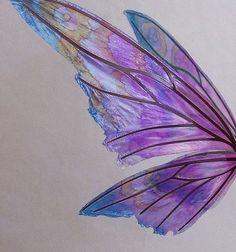 a purple and blue butterfly flying in the air with its wings spread out to look like it