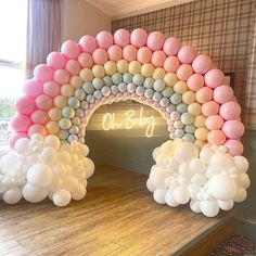 an arch made out of balloons with the word oh baby written on it in pink and white