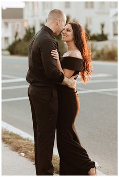 a man and woman standing next to each other in front of a street with buildings