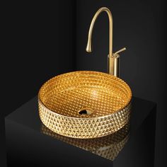 a golden sink sitting on top of a black counter