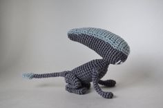 a crocheted stuffed animal sitting on top of a white table next to a gray wall