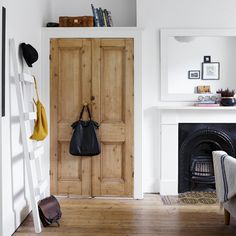 a white room with a wooden door and fireplace