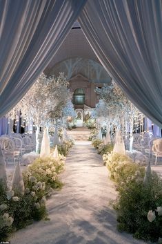 an outdoor wedding venue with white flowers and trees