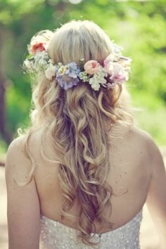 a woman with long hair and flowers in her hair is wearing a flowered headpiece