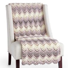 a chair with a crocheted blanket on it's back and armrests