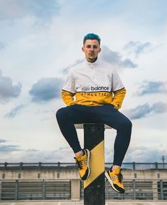 a man sitting on top of a skateboard in a parking lot