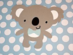 a paper cut out of a koala bear on a blue and white polka dot background