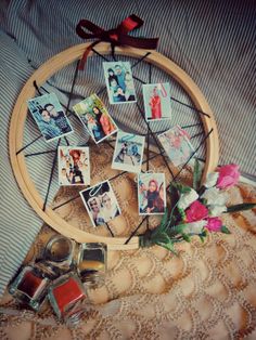 a basket filled with pictures sitting on top of a bed next to flowers and jars