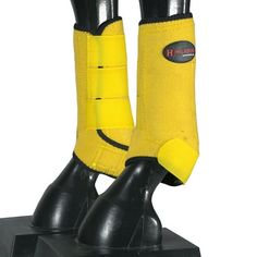 a pair of black and yellow boots on top of a metal stand with one foot in the air