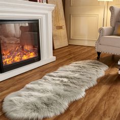 a living room with a fire place in the center and a chair next to it