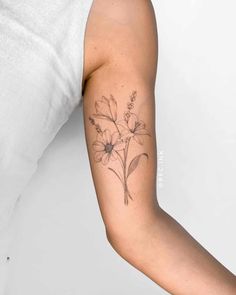 a woman's arm with a flower tattoo on the left side of her arm